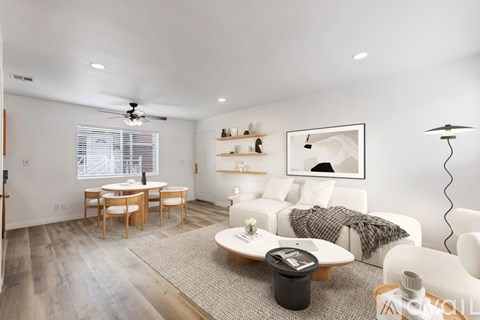 A modern living room with a white sofa set and a wooden coffee table.