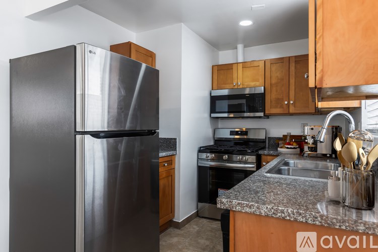 A kitchen with a black refrigerator and a stainless steel oven.