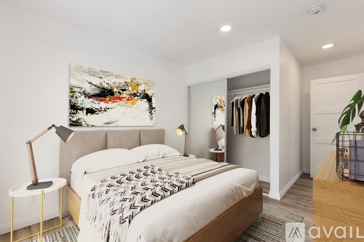 A bedroom with a large bed and a painting on the wall.