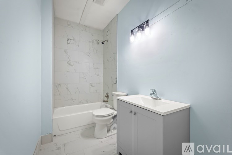 A bathroom with a white tub, toilet, and sink.