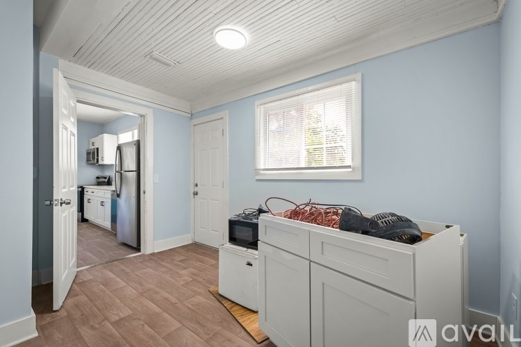 A room with a bed, a fridge, and a window.