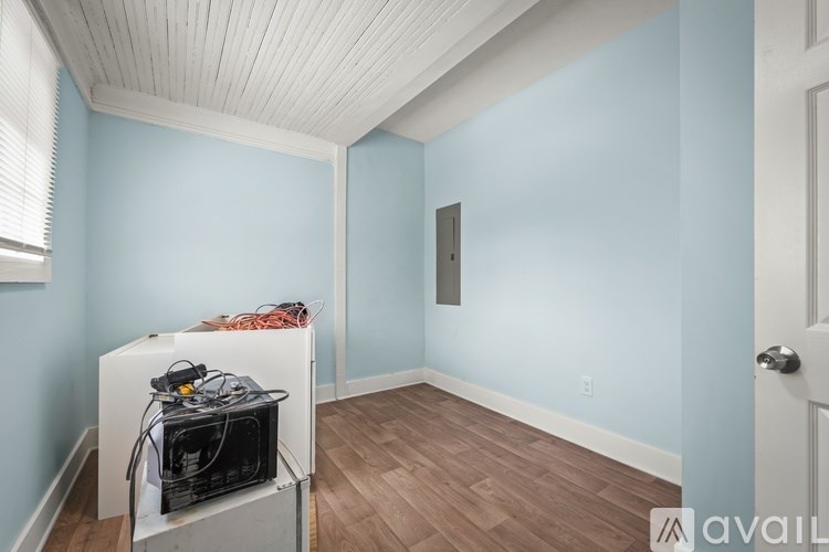 A room with light blue walls and a wooden floor.