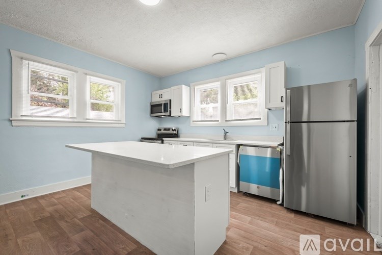 A kitchen with a white counter and a refrigerator.