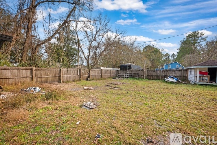 A backyard with a fence and a shed.