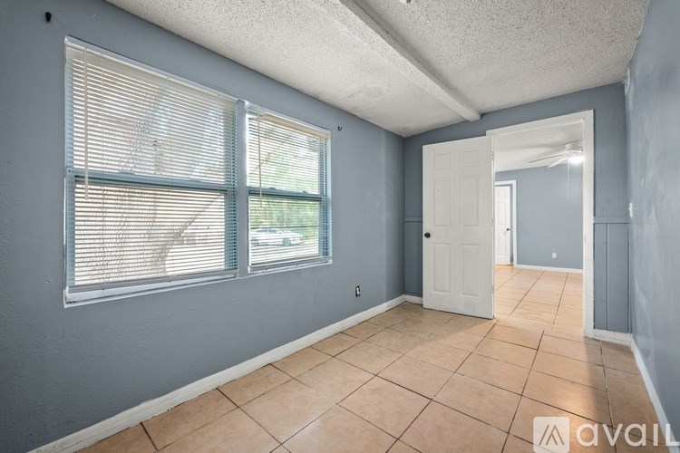 A room with a window and a door is available for rent.