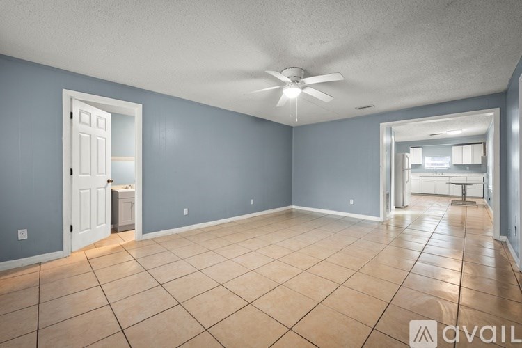A spacious room with a ceiling fan and tile flooring.