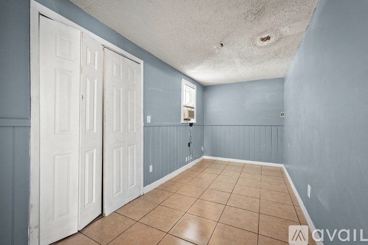 A room with a white door and tiled floor.