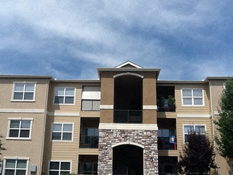 A large apartment building with a stone pillar in the center.