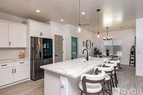 A modern kitchen with a large island and bar stools.