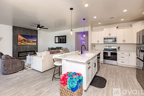 A modern kitchen and living room with a fireplace and a painting on the wall.