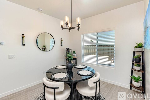 A dining room with a round table and chairs.