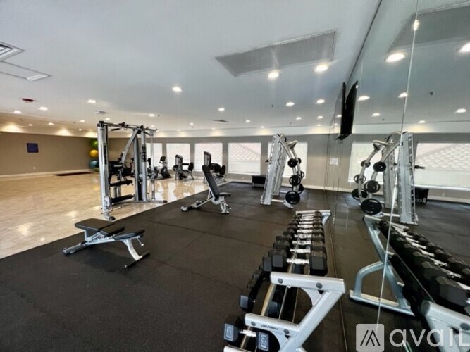 A gym with a variety of equipment including weights and machines.