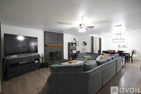 A living room with a grey couch and a fireplace.