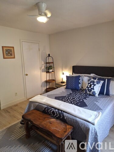 A white door with a black handle is open to a hallway.