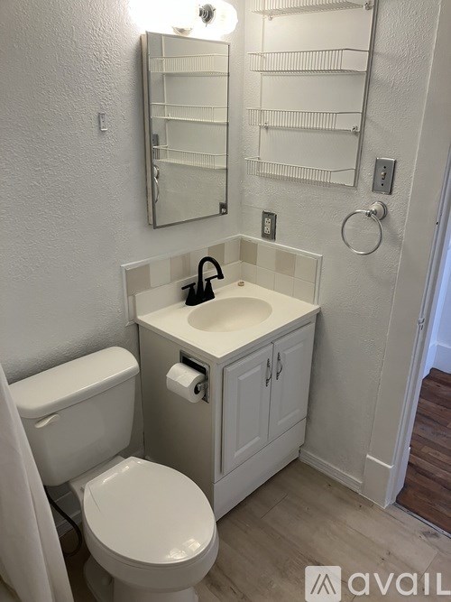 A white toilet and sink in a small bathroom.