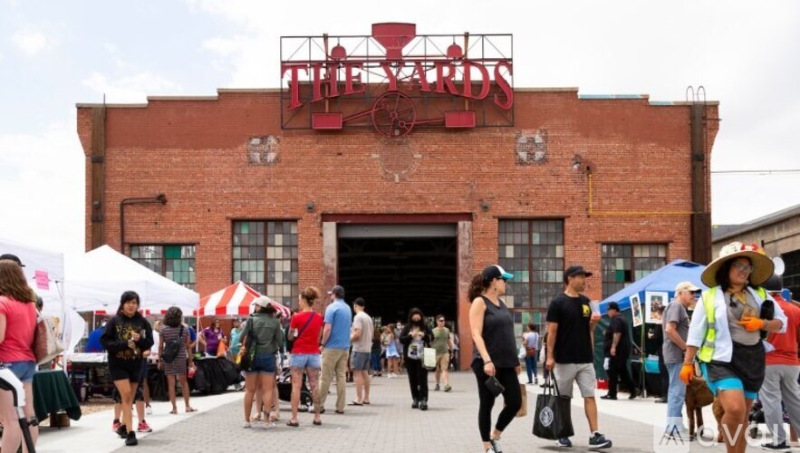 A group of people are walking in front of a red brick building with a sign that says "The Card".