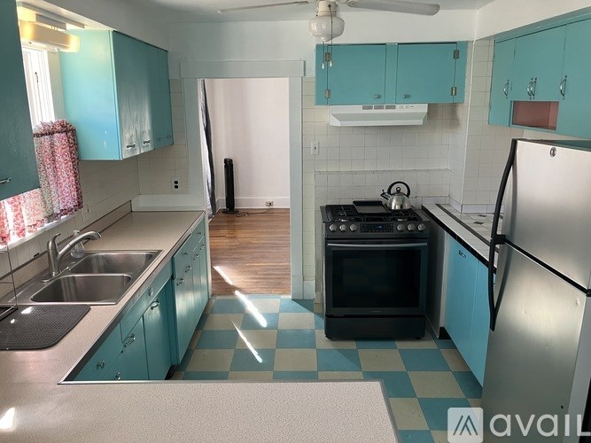 A kitchen with a black oven and a checkered floor.