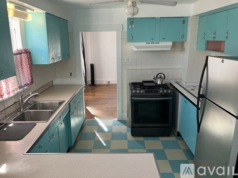 A kitchen with a black oven and a checkered floor.