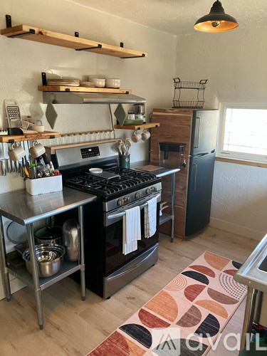 A kitchen with a checkered floor and a ceiling fan.