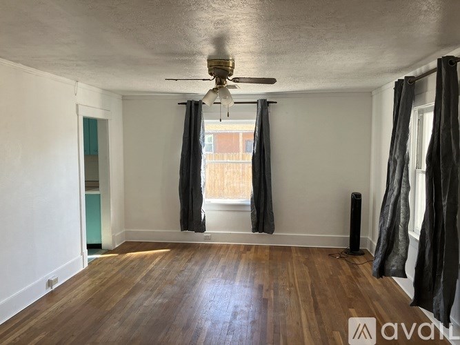 A room with wooden floors and a ceiling fan.