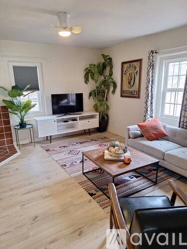 A room with a ceiling fan and wooden flooring.