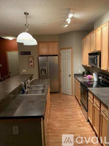 A kitchen with wooden cabinets and a black counter top.