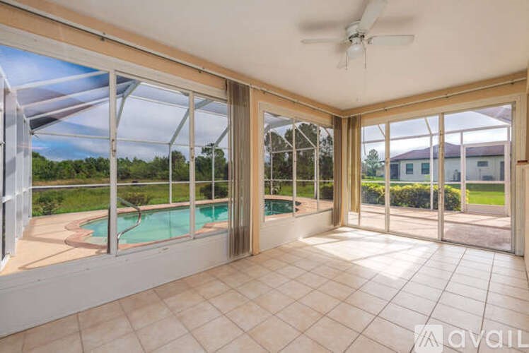 A room with a pool and sliding glass doors.
