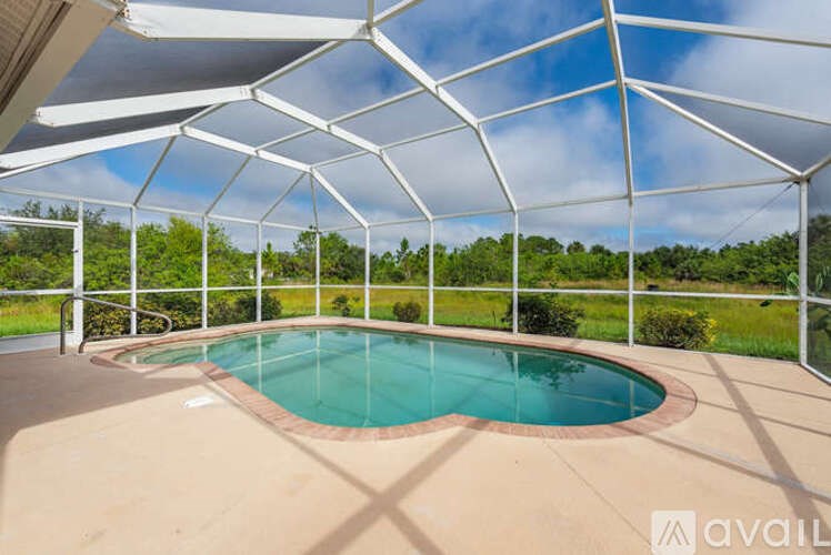 A pool enclosed by a white metal fence.