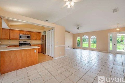 A spacious kitchen with wooden cabinets and a white countertop.
