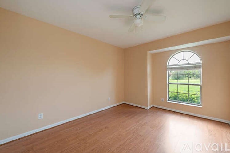 A room with a window and a ceiling fan.