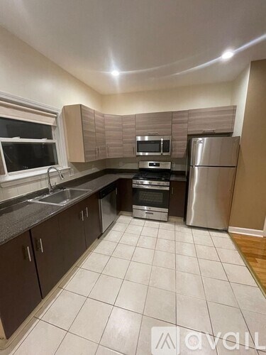 A kitchen with a refrigerator, oven, and sink.