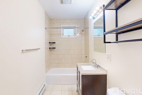 A bathroom with a white tub, sink, and a mirror.