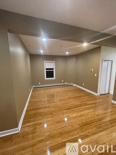 A room with wooden flooring and a window.