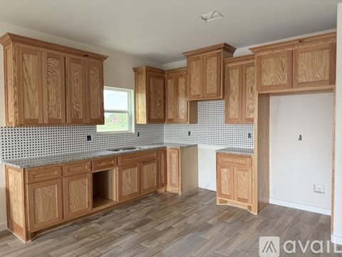 A kitchen with wooden cabinets and a tiled backsplash.