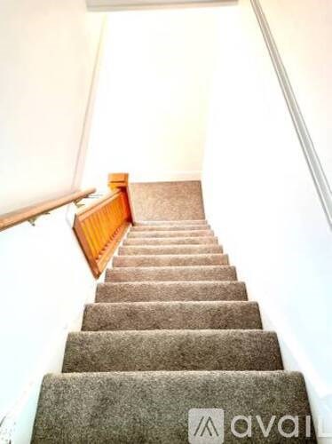 A white shelf with a pillow and a picture frame on it.