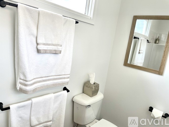 Two white towels hanging on a towel rack in a bathroom.