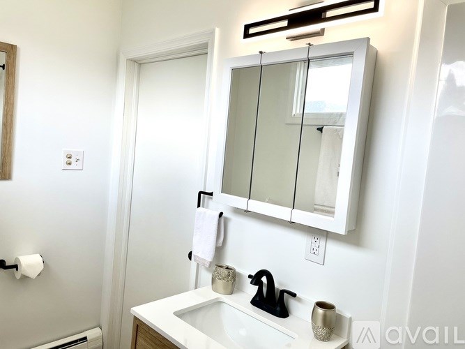 A bathroom with a white sink and a mirror above it.