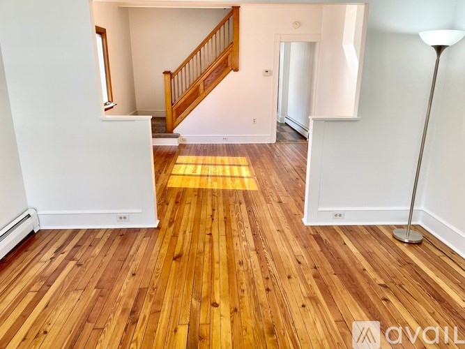 A room with wooden floors and a staircase.