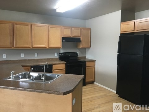 A kitchen with wooden cabinets and black appliances.