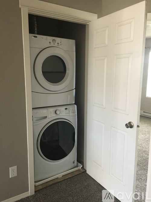 A white door is open to a laundry room with two washing machines.