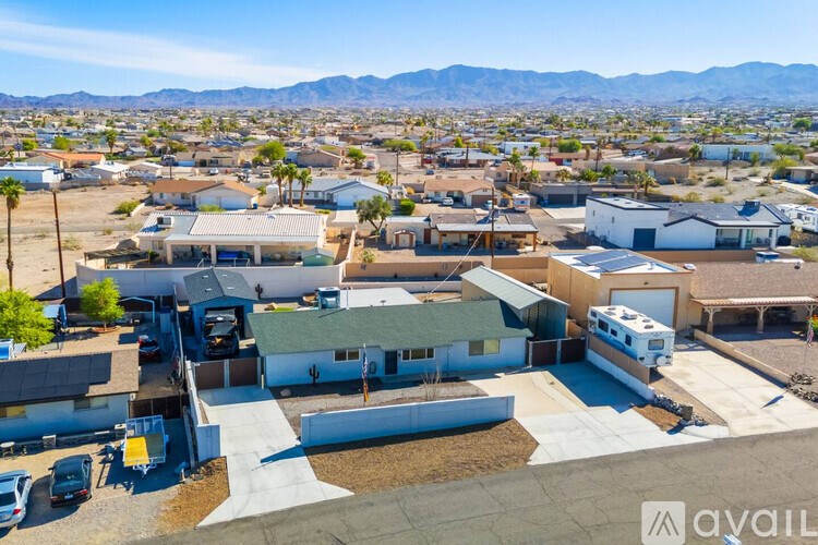 A sunny day in a residential area with houses and a clear blue sky.