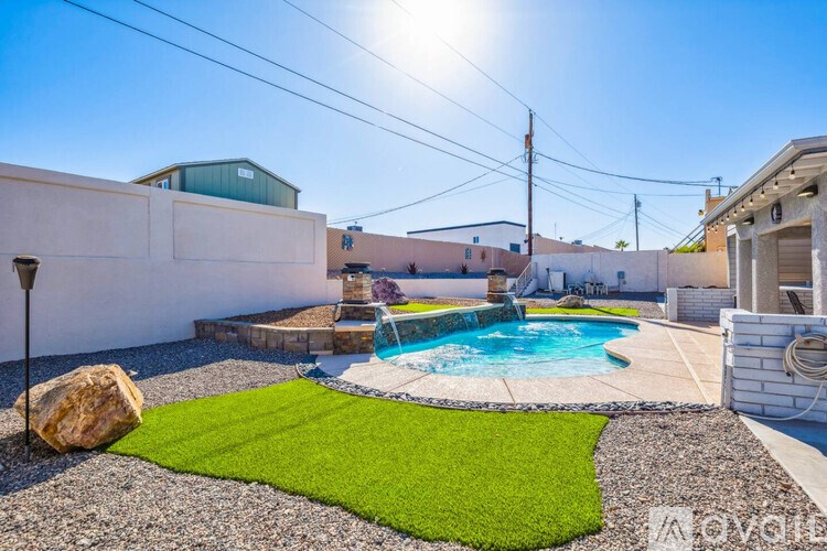 A backyard with a pool and a rock.
