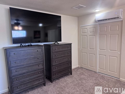 A bedroom with two dressers and a large mirror.