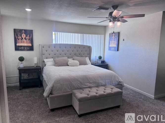 A bedroom with a large bed and a ceiling fan.