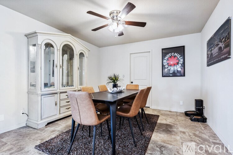 A dining room with a table set for two and a plant on it.