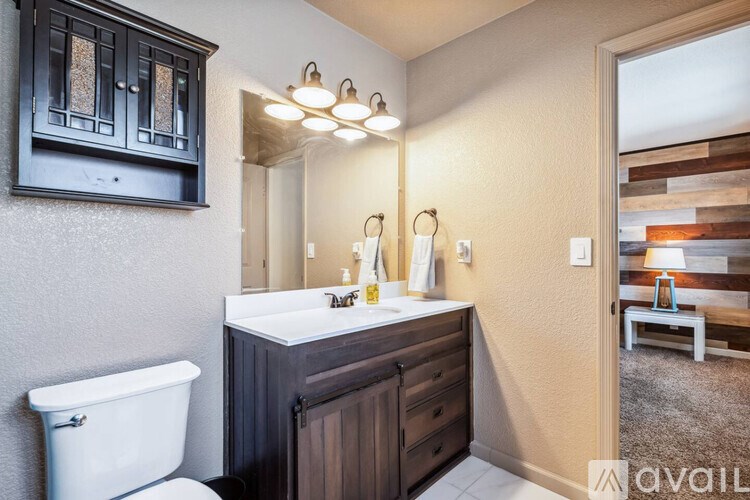 A bathroom with a white sink and a white toilet.