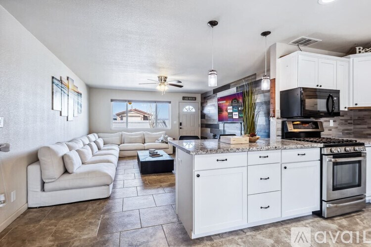 A modern kitchen with white cabinets and appliances.