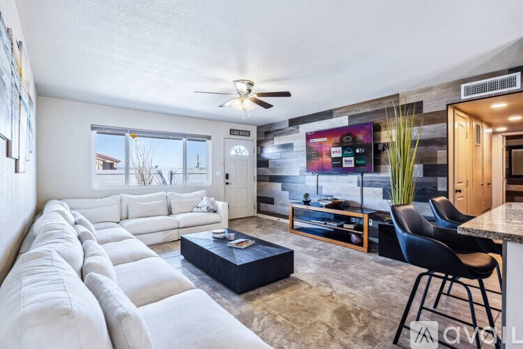 A living room with a long white couch and a black coffee table.