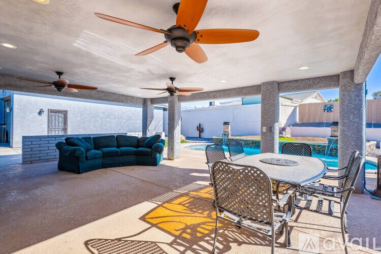A patio with a table and chairs and a ceiling fan.