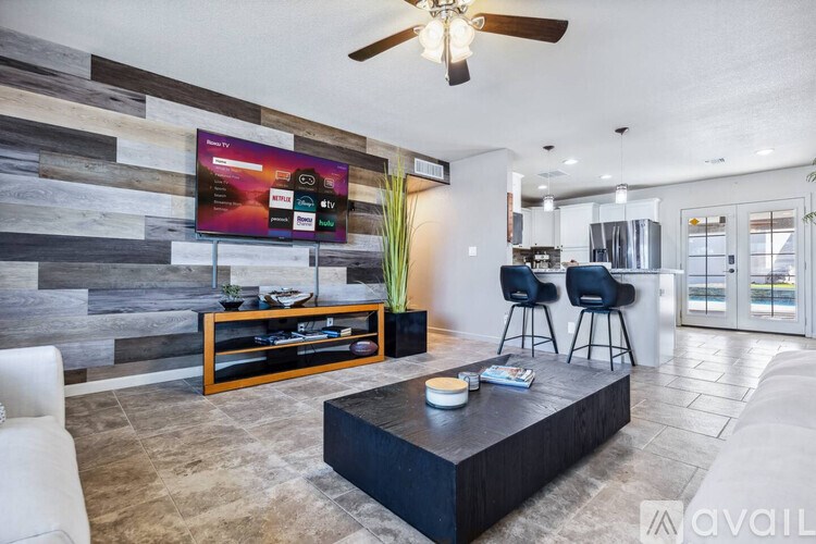 A modern living room with a flat screen TV mounted on a wooden wall.